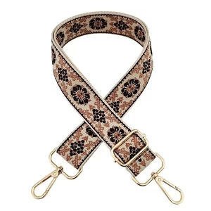 Detail of bohemian embroidered wide bag strap with gold metal hardware and floral pattern