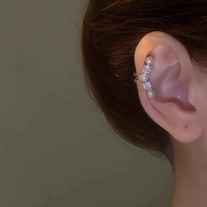 Elegant gold ear cuff featuring sparkling cubic zirconia and white pearls on a model