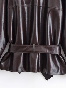 Detail of the high-gloss dark brown leather jacket waist belt and soft pleat design