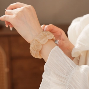 Detail of creamy apricot marble resin wide bracelet with stretch link construction