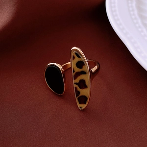Detailed close-up of a vintage leopard print open ring on a deep red fabric background