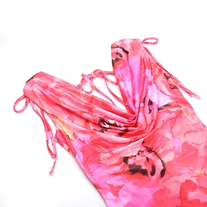 Dettaglio dell'abito in raso rosa a fiori con spalline sottili e scollo a cappuccio