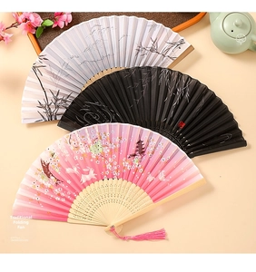 Detailed macro view of oriental folding fans with bamboo frames and floral patterns