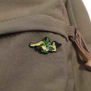 Macro shot of an enamel Creature from the Black Lagoon brooch on khaki canvas fabric