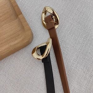 Close-up of leather waist chains with golden irregular oval buckles in black and brown