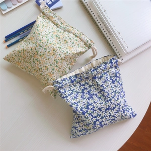 Detailed view of floral cotton drawstring pouches on white desk for storage