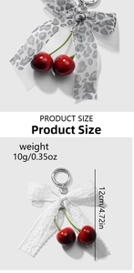 Detail view of red cherry keychain with leopard print and lace bows featuring metal clasp