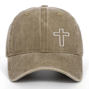 Close-up of white cross embroidery on vintage washed khaki cotton baseball cap