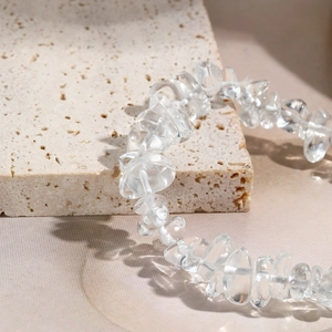 Macro shot of transparent natural stone beads on a textured light beige travertine base