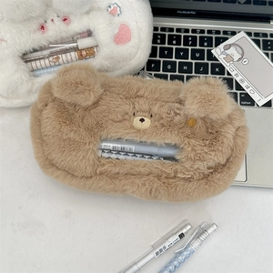 Macro shot of fluffy brown bear plush pencil case with embroidery on a desktop