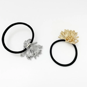 Detailed shot of black elastic hair ties with gold and silver metallic flower accents