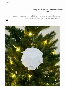 Close-up of white foam petal Christmas ball ornament with silver cap on festive Xmas tree