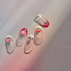 Detailed view of handmade press-on nails featuring 3D peaches and crystal heart accents
