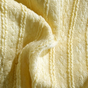 Macro shot of pale yellow bikini with detailed vertical ribbed knit texture and soft fabric