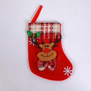 Detail of red Christmas stocking with cartoon reindeer and plaid cuff on white background