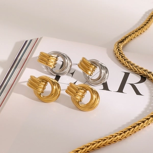 Twisted knot earrings in 18k gold and silver tones on a stylish chain background