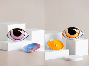 Detail view of ceramic evil eye decorative trays with gold edges in pink and orange
