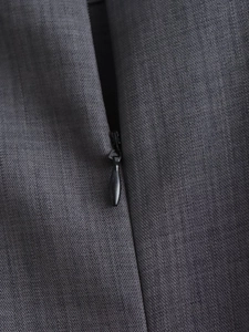 Close-up of the black invisible zipper and fine gray fabric texture on the sleeveless dress