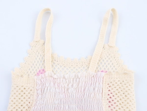 Detail of crochet knit top featuring smocked fabric and delicate hollow mesh texture
