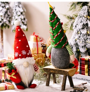 Close-up of plush Christmas gnomes with pearl accents on snow background