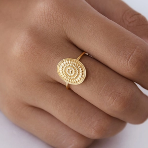 Vintage 18k gold plated sunburst mandala ring shown on a finger in a close-up view