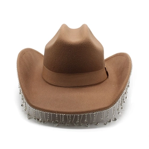 Dettaglio cappello da cowboy kaki con frange di strass scintillanti sulla tesa