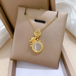 Détail du pendentif sac de chance doré avec pierre opale et cristaux brillants