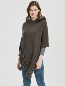Detail of dark coffee knitted poncho with faux fur collar and fringe tassels