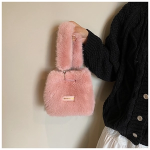 Detail of pink faux fur bucket bag featuring metal chain and Love Every Day plaque