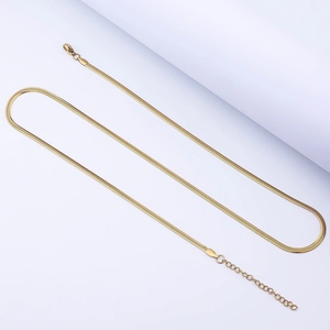 Detailed close-up of golden flat snake chain necklace with lobster clasp and extender