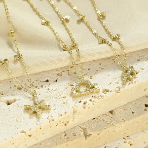 Detailed view of gold zodiac necklaces with zircon pendants on elegant stone surface
