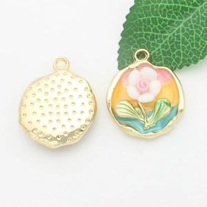 Detailed view of gold alloy floral enamel charms with pink petals and textured back