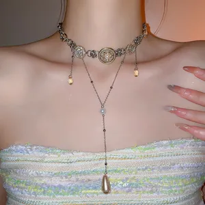 Close-up of double-layer vintage necklace with crystal medallions and teardrop pendants