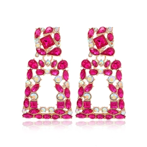 Detail view of pink and gold geometric earrings featuring sparkling rhinestones