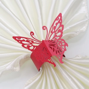 Detailed view of red laser-cut butterfly paper napkin ring on white silk napkin