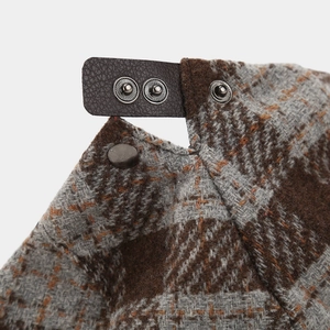 Macro detail of houndstooth wool fabric with leather adjustment strap and metal buckle