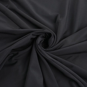 Detailed close-up of high-elastic black knitted fabric with textured spiral pleats