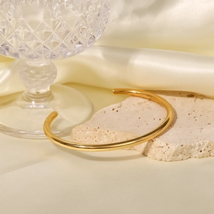 Bracciale rigido aperto minimalista in acciaio placcato oro 18K su pietra e seta