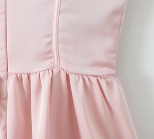 Vue détaillée de la taille de la robe rose avec coutures verticales et jupe plissée