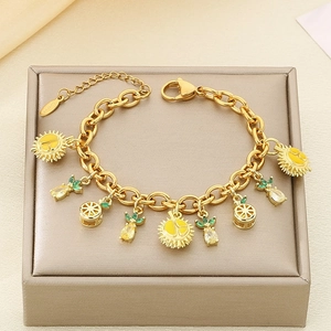 Detail of gold fruit charms including durian and pineapple on a zircon link bracelet