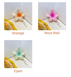 Macro detail of candy-colored plumeria hair claws in orange, pink, and cyan resin