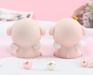 Detail of pink pig figurines with wings and crowns on a romantic decorative background