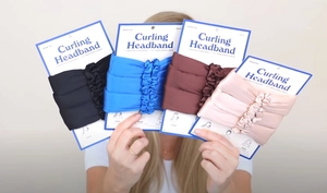 Four heatless curling headbands in black, blue, brown, and pink with retail packaging