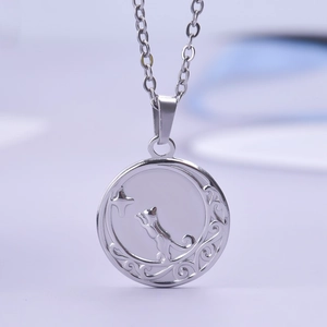 Detailed macro view of silver pendant with cat, moon, and star motifs in scrollwork frame