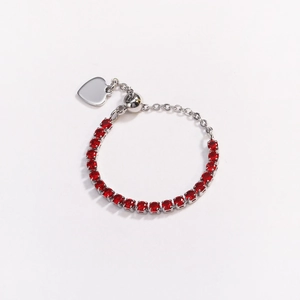 Detail of silver-tone adjustable ring featuring vibrant red zircons and heart charm pendant