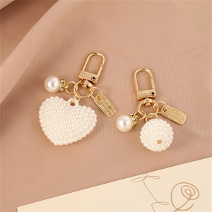 Golden alloy keychain with white faux pearl heart and sphere charms for bags and earphones