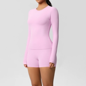 Detailed texture of pink long-sleeved yoga top and high-waist fitness shorts