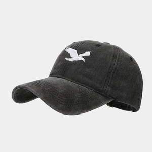 Detail view of a vintage washed black baseball cap featuring white eagle embroidery