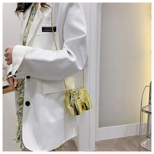 Artistic gold torso shaped mini crossbody bag with a sleek metallic chain strap
