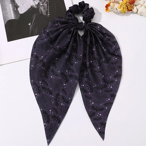 Détail d'un chouchou Halloween violet avec motifs chauves-souris et araignées
